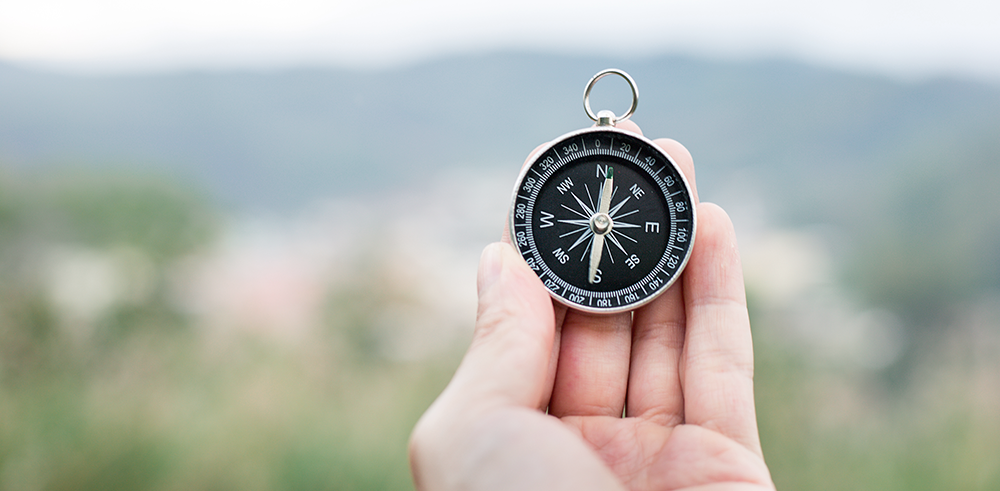 Hand som håller en kompass
